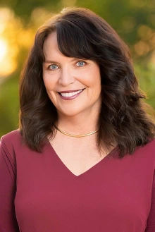 Portrait of Dr. Ann Marie Chiasson in an outdoor setting with trees behind her.