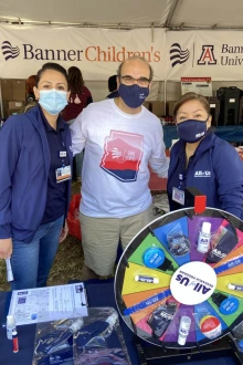 Andreas Theodorou, MD, (center) professor and vice chair of the Department of Pediatrics at the College of Medicine – Tucson, pediatric intensive care doctor at Banner Health and co-PI for All of Us UArizona – Banner, promotes the program at the El Tour de Tucson with engagement coordinators Brenda Mora Perez (left) and Susana Vásquez (right).