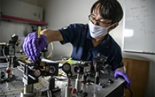 Dr. Dongkyun Kang works to align the laser optics to increase the light power of a portable confocal microscope he is developing with Dr. Clara Curiel Lewandrowski. (Photo: Kris Hanning/ University of Arizona Health Sciences)