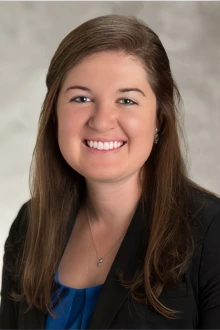 Portrait of a smiling white woman with long dark hair. 