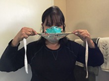 A model demonstrates the proper use of a homemade face mask in tandem with an N95 respirator mask.