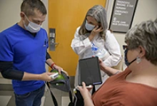 Cristian Laguillo, MD, Copper Queen Community Hospital inpatient medicine director and a UArizona College of Medicine adjunct faculty member, discusses the bedside ultrasound machine with Julia Brown, MD, and Glenda Trevino, RN, nursing education director. (Photo: University of Arizona Health Sciences, Kris Hanning)