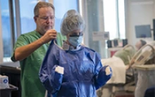 Health care workers don personal protective equipment, known as PPE, before treating patients with the virus that causes COVID-19. Some research conducted during the pandemic included efficacy of PPE to protect against the virus’ spread. (Photo: Noelle Haro-Gomez/University of Arizona Health Sciences)