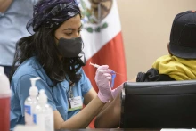 College of Medicine – Tucson senior medical student Maya Sarihan gives a COVID-19 vaccination to an agricultural laborer April 23 during a MOVE UP clinic at the Mexican Consulate in Douglas, Arizona.