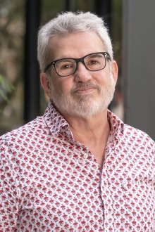 Portrait of a white man with short gray hair and beard. 