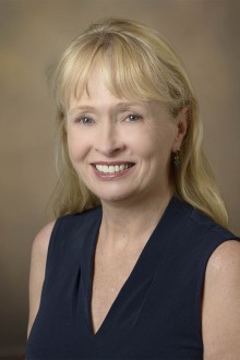 Portrait of professor Patricia Daly, a smiling light-skinned woman with long, straight blonde hair.