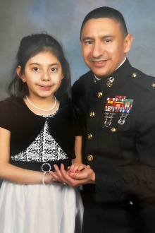 man in military uniform posing with young daughter