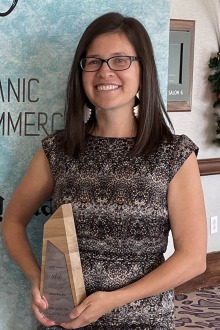 Portrait of Dr. Bernadette Cornelison holding an award while smiling. 