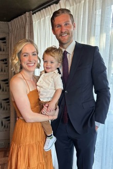 a man and woman in formal attire with their toddler son