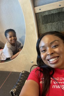 Black woman takes selfie with daughter in background