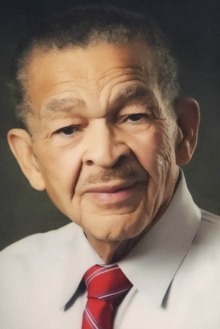 Portrait of an older Black man wearing a tan dress shirt and red tie