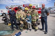 Simulated crash training crews with Alex Matthews (left), her son, Jamison (holding jaws-of-life device), and Glendale Fire paramedics. Alex and Jamison were in a motor vehicle accident in December 2012, where Alex used the EPIC-TBI prehospital care guidelines to help save the life of her son. (Photo: Sun Belous, University of Arizona College of Medicine – Phoenix)