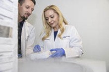 Drs. Melissa Herbst-Kralovetz and Paweł Łaniewski select cells preserved through cryopreservation, a technique that can freeze cells without damaging them. (Photo: Kris Hanning/University of Arizona Health Sciences)