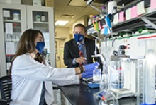 Doctoral student Lisa Boinon prepares buffers under the watchful eye of Dr. Khanna, her faculty mentor. (Photo: Kris Hanning/University of Arizona Health Sciences)