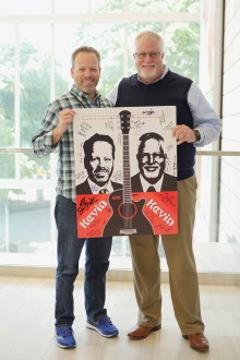 Kevin Schuer and Kevin Lohenry pose with band posters