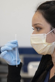 Clinical research coordinator Brenna Abril instructs students in self-administering the nasal swab antigen test at the University of Arizona Recreation and Wellness Center, known as NorthREC, in Tucson.