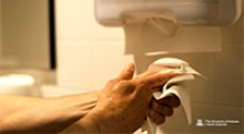 A person using a paper towel to dry after washing their hands. (Photo: University of Arizona Health Sciences)