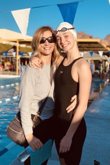 mother and daughter standing together at poolside