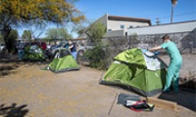 University of Arizona medical students (from left to right: Christian Bergman, Erika Krall and Christopher Vance) build camping tents on the property of Z Mansion. The tents will serve as isolation units for homeless individuals who are suspected to have COVID-19. (Photo: The University of Arizona Health Sciences, Rick Kopstein)